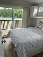 Primary Bedroom with patio doors to an extended covered deck. - 