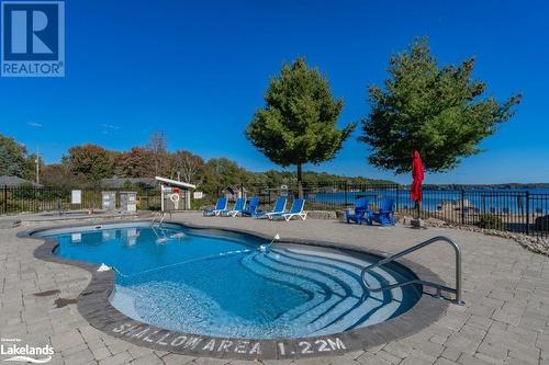 Pool & hot tub at the beach - 1869 Muskoka 118 Highway W Unit# A201-C1 Or C2, Muskoka Lakes, ON - Outdoor With In Ground Pool With Deck Patio Veranda With View