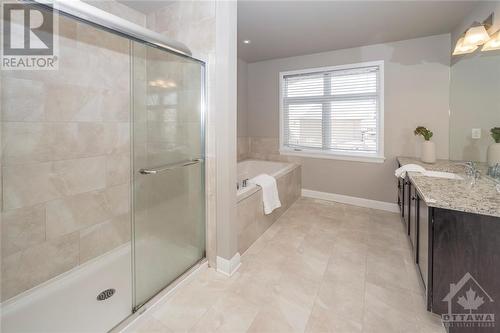 The ensuite features a walk-in shower and soaker tub, two sinks, and gorgeous finished throughout including granite counters - 268 Huntsville Drive, Ottawa, ON - Indoor Photo Showing Bathroom