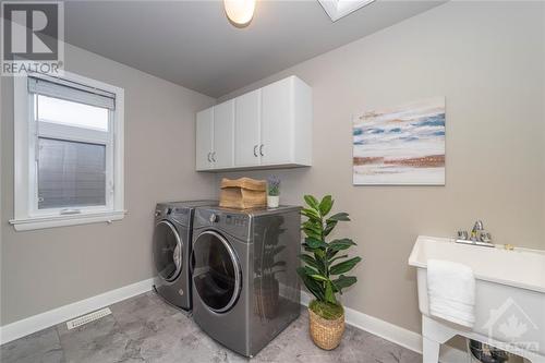 The very convenient 2nd level laundry room is incredibly spacious, and features a washer & dryer, tub, and cabinetry. - 268 Huntsville Drive, Ottawa, ON - Indoor Photo Showing Laundry Room