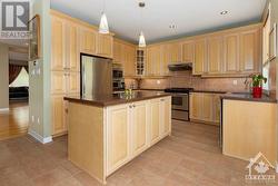 Kitchen features granite counter tops, plenty of pot-lights, custom builder cabinets, tile floors - 