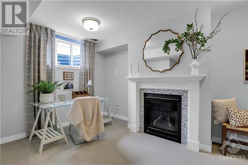 convenient "nook" in lower level, provides a nice workspace.  Fireplace shown in the model home is not included in the actual property. - 91 Mandevilla Crescent, Ottawa, ON - Indoor Photo Showing Living Room With Fireplace