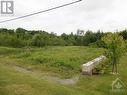 Photo of the eastern property line. The retaining wall is part of the property as per surveyor's pin beside the wooden post with red flag. - Pt Lot 5 Labonte Street, Clarence Creek, ON 