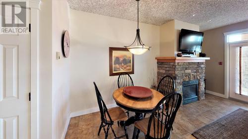 400 Bighorn  Boulevard Unit# 415 G, Radium Hot Springs, BC - Indoor Photo Showing Dining Room With Fireplace