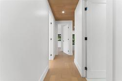Upper hallway. Pot lighting. White oak flooring and ceiling. - 