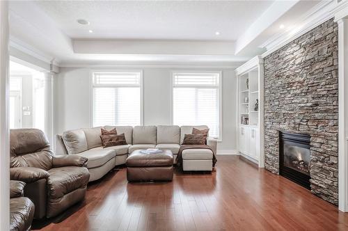 Gas fireplace with stone surround and built ins - 4072 Highland Park Drive, Beamsville, ON - Indoor Photo Showing Living Room With Fireplace