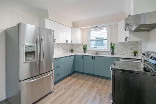 Brand new kitchen in main floor unit features stainless steel fridge, stove, hood vent and dishwasher. - 19 Fawell Avenue, St. Catharines, ON - Indoor Photo Showing Kitchen With Double Sink