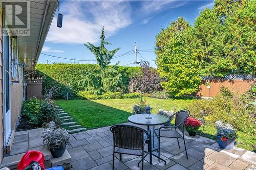 BACK | summer 2023 backyard boasts patio and surrounding Weeping Cyprus Tree, Yellow Magnolia Tree, Smoke Bush & various perennials, etc. - 1417 Duford Drive, Orleans, ON - Outdoor With Deck Patio Veranda