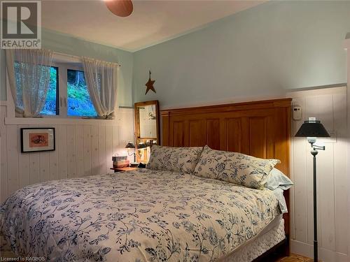 Master with custom whitewash wainscotting and wonderful views of the Niagara Escarpment behind the home. - 61 North Shore Road, Northern Bruce Peninsula, ON - Indoor Photo Showing Bedroom