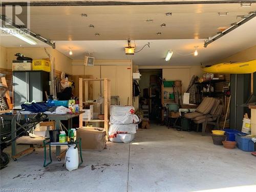 Lower level has a 16ft automatic overhead door, finished interior and custom utility storage cabinets. - 61 North Shore Road, Northern Bruce Peninsula, ON - Indoor Photo Showing Garage
