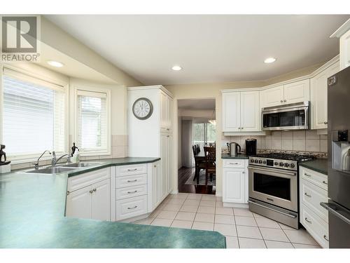 3973 Gallaghers Circle, Kelowna, BC - Indoor Photo Showing Dining Room With Fireplace