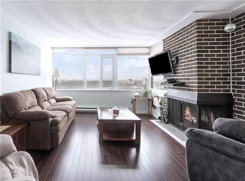 Cozy Wood-Burning Fireplace with Views of Toronto Skyline & Lake - 30 Harrisford Street|Unit #1001, Hamilton, ON - Indoor Photo Showing Living Room With Fireplace