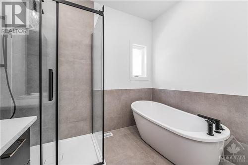 with glass shower enclosure and stand-alone soaker tub - 1344 Diamond Street, Clarence-Rockland, ON - Indoor Photo Showing Bathroom