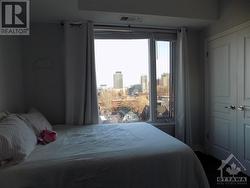 primary bedroom with a large window and a view - 