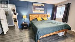 The master bedroom is large and has a pretty wedgewood blue feature wall. - 