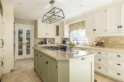 The  darker coloured granite countertop on the island  offers a lovely contrast. - 