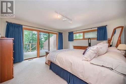 Spacious Primary Bedroom with ensuite bath and access to deck. - 27 Rocky Shores Lane, Round Lake Centre, ON - Indoor Photo Showing Bedroom