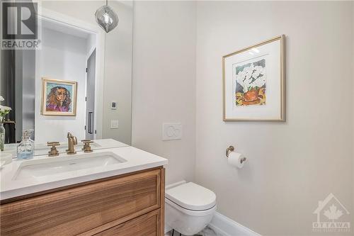 Powder room with heated porcelain floors thoughtfully tucked away from entertaining spaces - 434 Kenwood Avenue, Ottawa, ON - Indoor Photo Showing Bathroom