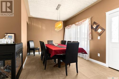 6037 Eagles Cove, Regina, SK - Indoor Photo Showing Dining Room With Fireplace