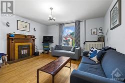 Unit 2-Living room with decorative fireplace. Bright, spacious with high ceilings. Beautiful hardwood floors. This living room is currently being used as a bedroom. - 