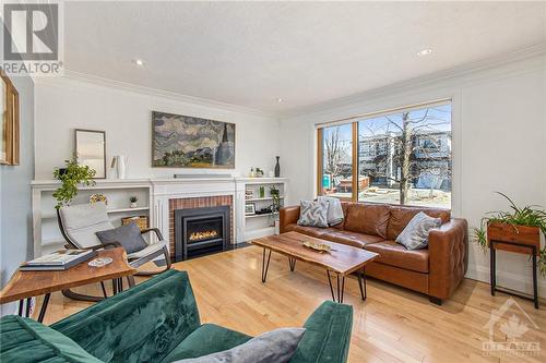 The formal living room has been updated with a gas fireplace but has maintained charm with original built-ins - 462 Dawson Avenue, Ottawa, ON - Indoor Photo Showing Living Room With Fireplace