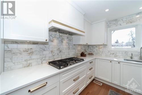 Renovated Kitchen with Custom Cabinets, Quartz Counters, Large Centre Island with Seating for 4, Stainless Steel Appliances and Hardwood Floors - 48 Marble Arch Crescent, Ottawa, ON - Indoor Photo Showing Kitchen