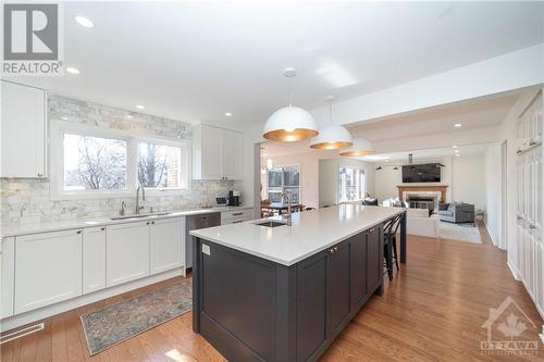 Renovated Kitchen with Custom Cabinets, Quartz Counters, Large Centre Island with Seating for 4, Stainless Steel Appliances and Hardwood Floors - 48 Marble Arch Crescent, Ottawa, ON - Indoor Photo Showing Kitchen With Upgraded Kitchen