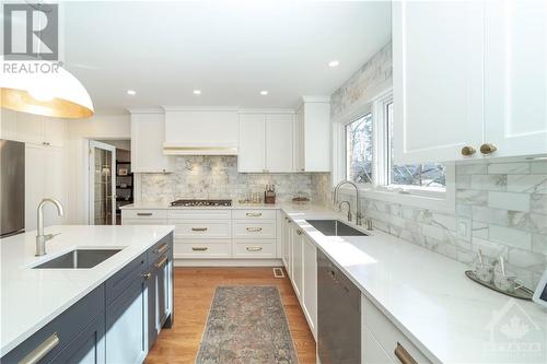 Renovated Kitchen with Custom Cabinets, Quartz Counters, Large Centre Island with Seating for 4, Stainless Steel Appliances and Hardwood Floors - 48 Marble Arch Crescent, Ottawa, ON - Indoor Photo Showing Kitchen With Upgraded Kitchen