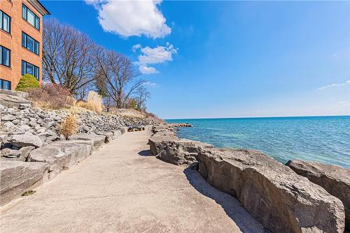 Private lake front with common areas for entertaining complete with BBQ. - 2220 Lakeshore Road|Unit #11, Burlington, ON - Outdoor With Body Of Water With View