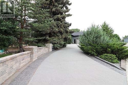 Looking up towards the home from the second driveway entrance - 52 Greystone Close E, Brooks, AB - Outdoor