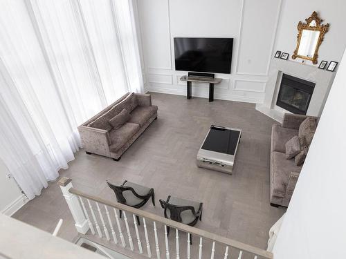 Mezzanine - 12 Rue Pierre-Trudeau, Dollard-Des-Ormeaux, QC - Indoor Photo Showing Living Room With Fireplace