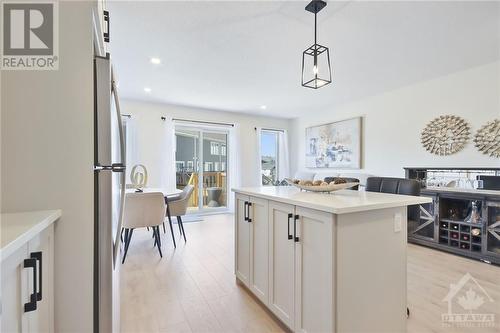 Step into a beautiful, bright kitchen featuring hardwood floors, stainless steel appliances, granite countertops, and a kitchen island, complete with a sliding door in the nook that opens to a cha - 10 Whitcomb Crescent, Smiths Falls, ON - Indoor