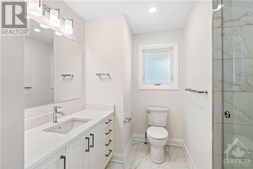 This custom bathroom includes; ‘soft-close’ vanity cabinetry, quartz countertop, undermount sink with Moen faucet, large glass enclosed walk-in shower enclosure with tile walls/floor and rain show - 1235 Parkway Drive, Ottawa, ON - Indoor Photo Showing Bathroom