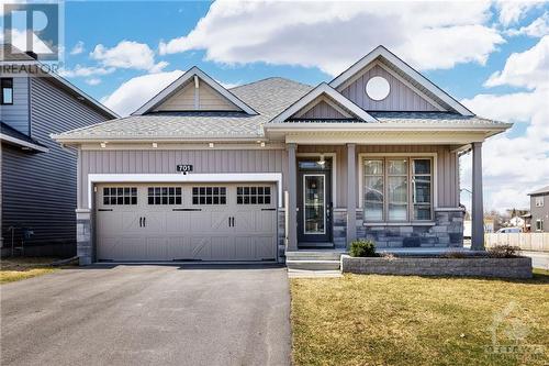 Corner lot bungalow with double garage and covered front porch located in EQ's desired community of Clarence Crossing - 701 Du Rivage Street, Rockland, ON - Outdoor With Facade