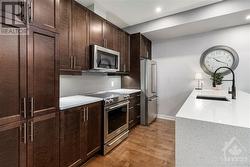 Main level kitchen with quartz counters, stainless steel appliances, shaker cupboard doors - 