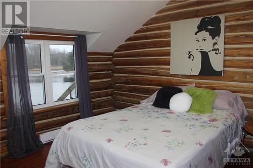 Original log walls are exposed in this primary bedroom. - 4220 Hwy 511 Highway, Lanark, ON - Indoor Photo Showing Bedroom