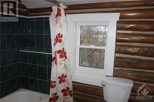 The bathroom too has some of the original log walls. - 4220 Hwy 511 Highway, Lanark, ON - Indoor Photo Showing Bathroom