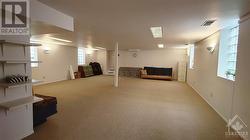 Lower level hall, carpeted and glass block windows, rear egress at back wall. - 