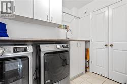 Second floor laundry with uppers, sink, countertop and large linen closet - 