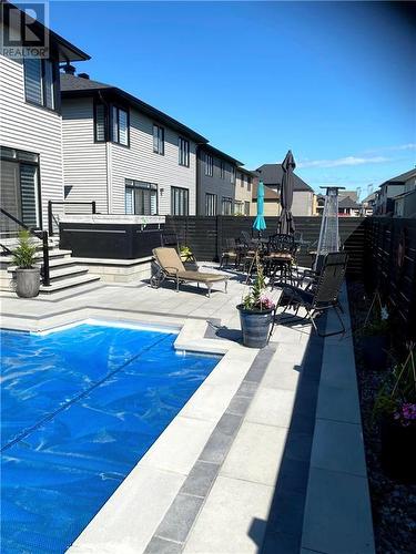 Pool area with glass rail at steps and hot tub - 165 Finsbury Avenue, Stittsville, ON - Outdoor With In Ground Pool