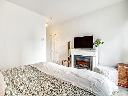 Chambre Ã  coucher principale - 105-1220 Boul. Lucille-Teasdale, Terrebonne (Lachenaie), QC - Indoor Photo Showing Bedroom With Fireplace