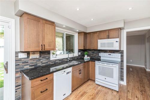 Update with warm wood cabinets and granite counters. - 64 Terrace Drive, Dundas, ON - Indoor Photo Showing Kitchen