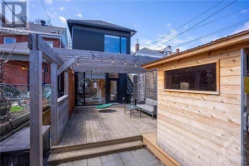 View of the backyard, large deck with monkey bars, rock wall and swing. This eastern facing yard is perfect for your morning coffee. - 163 Irving Avenue, Ottawa, ON - Outdoor With Deck Patio Veranda With Exterior