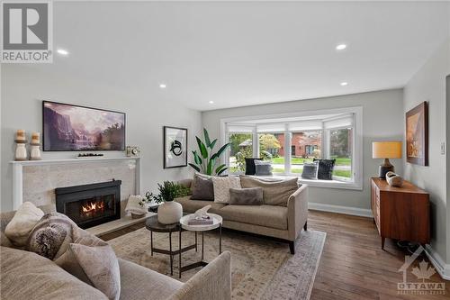 The main living room features a large bay window and an updated wood fireplace. - 10 Okanagan Drive, Ottawa, ON - Indoor Photo Showing Living Room With Fireplace