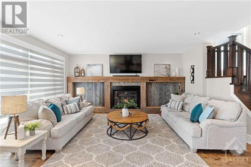 The inviting modern farmhouse-style family room offers a versatile space that can accommodate any furniture layout with ease. Whether you prefer a cozy seating area around the fireplace or a more - 52 Moore Street, Ottawa, ON - Indoor Photo Showing Living Room With Fireplace