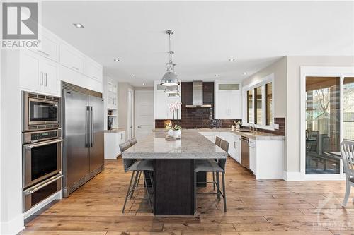 Large bright open-concept kitchen boasts stainless steel built-in appliances, granite countertops, and stunning white cabinets. This combination of sleek, modern features creates a timeless and el - 52 Moore Street, Ottawa, ON - Indoor Photo Showing Kitchen With Upgraded Kitchen