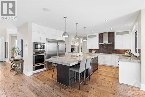Anchoring this chef-inspired kitchen are the side-by-side fridge freezer and gas cooktop, offering both style and functionality. Completing the ensemble is a convenient bar fridge with a built-in - 52 Moore Street, Ottawa, ON - Indoor Photo Showing Kitchen With Upgraded Kitchen
