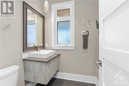 Conveniently positioned just outside the back foyer entrance from the garage, a stylish two-piece powder room graces the main level. - 52 Moore Street, Ottawa, ON - Indoor Photo Showing Bathroom