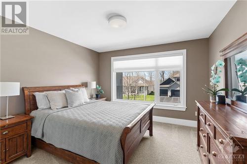 Plush secondary bedroom boasts soft carpeting and abundant natural light streaming in through the window, creating a cozy and inviting atmosphere - 52 Moore Street, Ottawa, ON - Indoor Photo Showing Bedroom