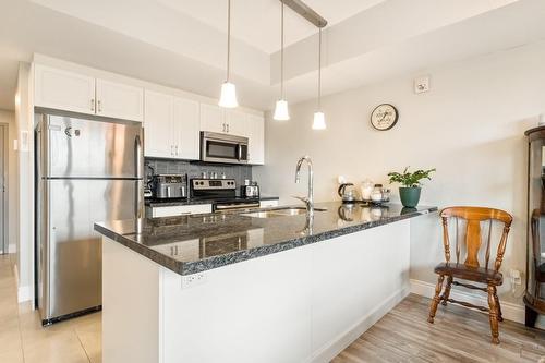 Kitchen boasts stainless steel appliances, tiled backsplash and granite counter tops. - 67 Haddington Street|Unit #304, Caledonia, ON - Indoor Photo Showing Kitchen With Double Sink With Upgraded Kitchen